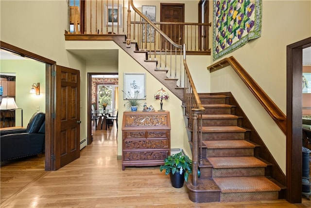 10 Bartlett Rd, Middletown, RI 02842 - stairs featuring wood finished floors, a baseboard radiator, and a high ceiling