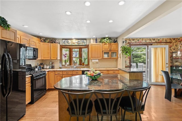 10 Bartlett Rd, Middletown, RI 02842 - kitchen featuring black appliances, a sink, a center island, light wood-style floors, and stone counters