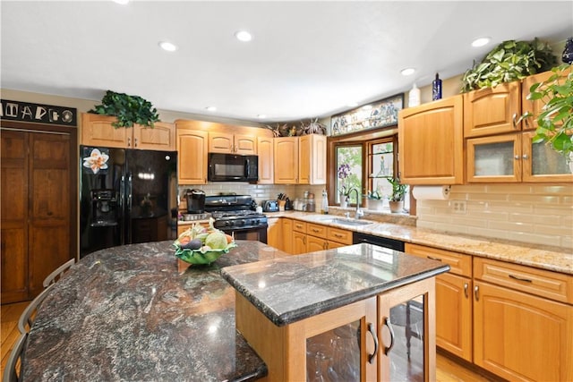 10 Bartlett Rd, Middletown, RI 02842 - kitchen featuring black appliances, a sink, a kitchen island, tasteful backsplash, and dark stone countertops