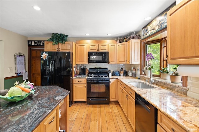 10 Bartlett Rd, Middletown, RI 02842 - kitchen with black appliances, a sink, light wood finished floors, light stone counters, and backsplash