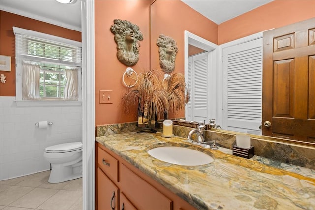 10 Bartlett Rd, Middletown, RI 02842 - bathroom featuring vanity, tile patterned flooring, toilet, tile walls, and a wainscoted wall