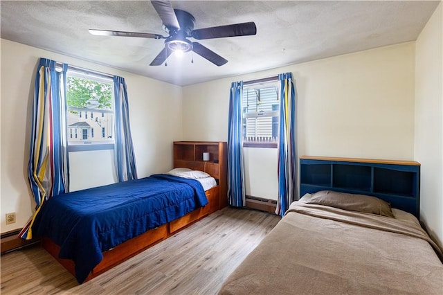 71 Julian St, Pawtucket, RI 02861 - bedroom featuring wood finished floors, baseboard heating, multiple windows, and a ceiling fan