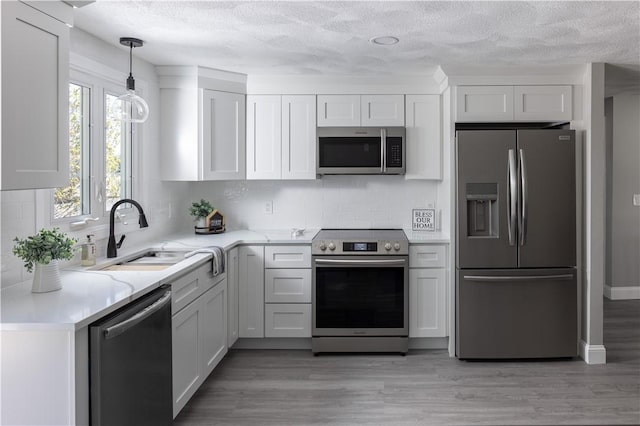 99 Scranton Ave, Warwick, RI 02888 - kitchen with appliances with stainless steel finishes, a sink, a textured ceiling, decorative backsplash, and white cabinetry