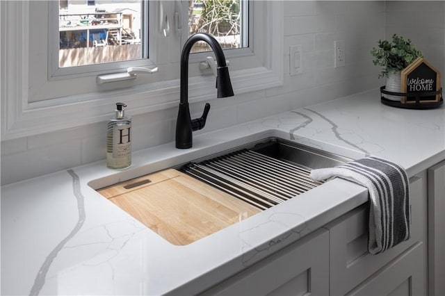 99 Scranton Ave, Warwick, RI 02888 - kitchen view of a sink, backsplash, and light stone countertops