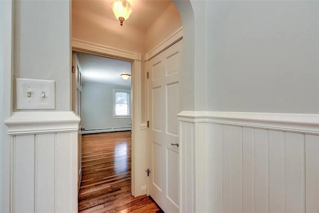 368 Thayer St Unit 2, Providence, RI 02906 - hall with arched walkways, a baseboard radiator, wood finished floors, and a wainscoted wall