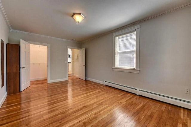 368 Thayer St Unit 2, Providence, RI 02906 - unfurnished bedroom featuring a baseboard heating unit, light wood-style flooring, crown molding, baseboards, and a spacious closet