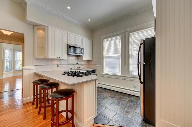 368 Thayer St Unit 2, Providence, RI 02906 - kitchen featuring a baseboard heating unit, stainless steel appliances, a kitchen breakfast bar, glass insert cabinets, and a peninsula
