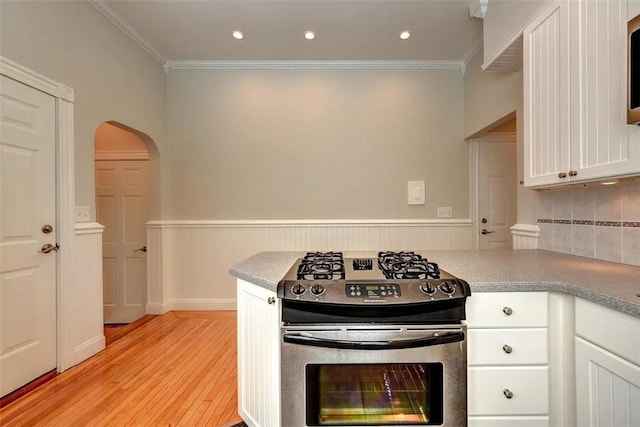 368 Thayer St Unit 2, Providence, RI 02906 - kitchen featuring stainless steel gas range oven, arched walkways, white cabinetry, wainscoting, and light wood-style floors