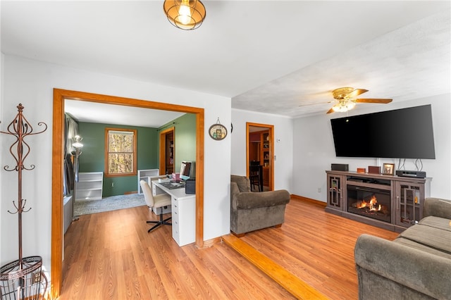 34 Bates Ave, Coventry, RI 02816 - living room featuring an office area, light wood-style flooring, a ceiling fan, a glass covered fireplace, and baseboards