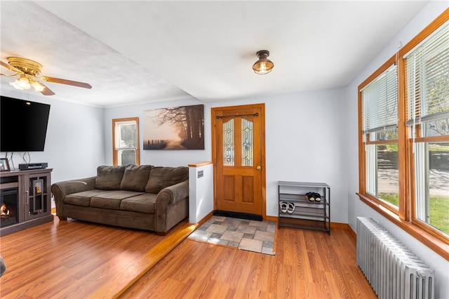 34 Bates Ave, Coventry, RI 02816 - living area featuring radiator, light wood finished floors, ceiling fan, and baseboards