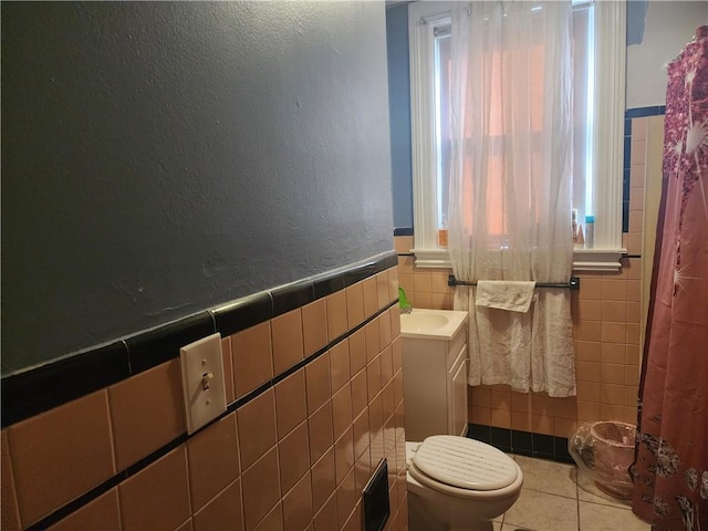 95 Congress Ave, Providence, RI 02907 - bathroom with tile walls, tile patterned floors, toilet, vanity, and a wainscoted wall