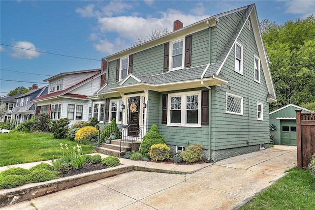 77 Glen Ave, Cranston, RI 02905 - view of front of property featuring an outbuilding, a garage, a chimney, roof with shingles, and a front lawn