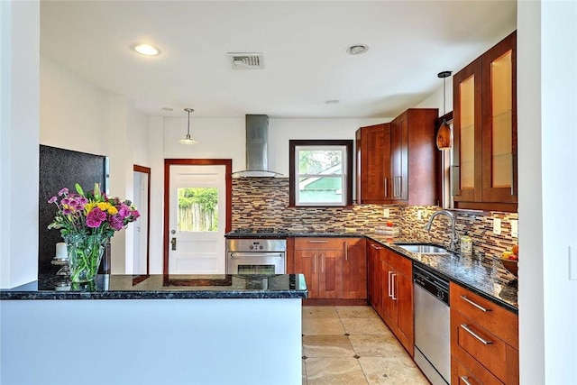 77 Glen Ave, Cranston, RI 02905 - kitchen with wall chimney range hood, appliances with stainless steel finishes, a sink, tasteful backsplash, and a peninsula