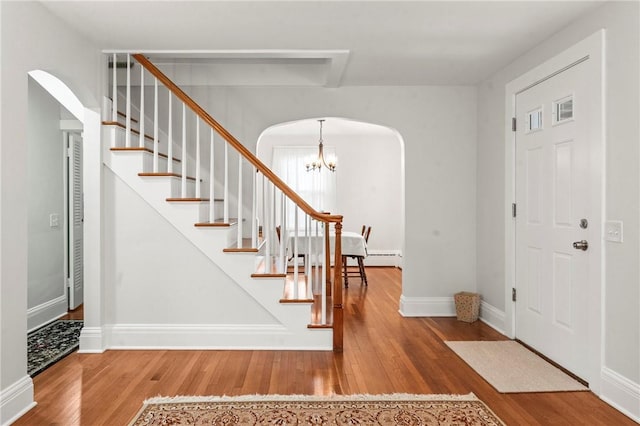 12 Arlington St, Westerly, RI 02891 - entrance foyer with arched walkways, wood finished floors, a chandelier, and stairs