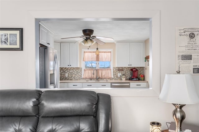 4 Aberdeen St, West Warwick, RI 02893 - kitchen featuring stainless steel appliances, a sink, decorative backsplash, white cabinetry, and light countertops