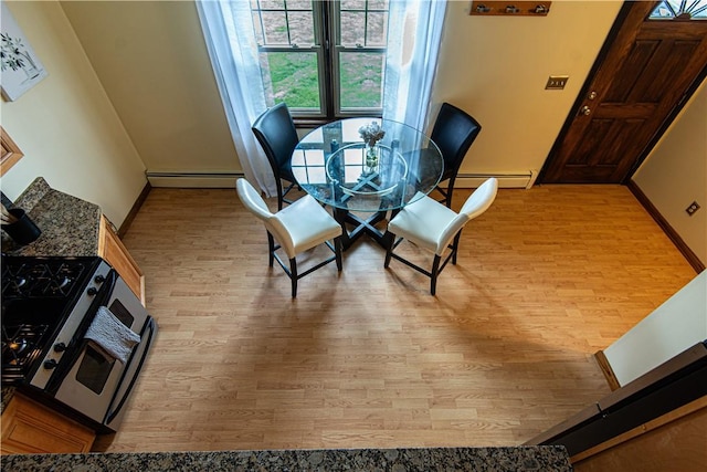 417 Privilege St, Woonsocket, RI 02895 - dining area featuring wood finished floors, a baseboard radiator, and baseboards