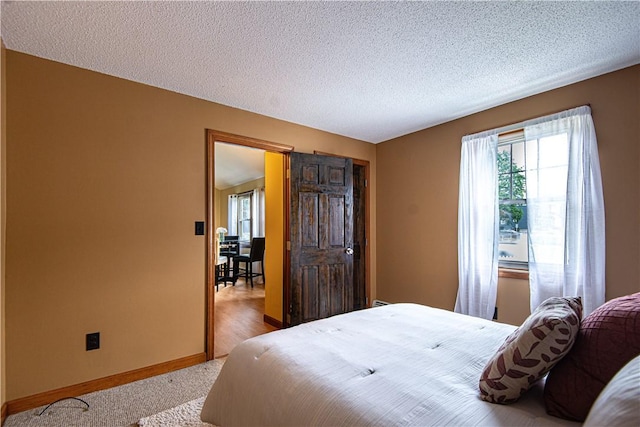417 Privilege St, Woonsocket, RI 02895 - bedroom with multiple windows, baseboards, a textured ceiling, and carpet flooring