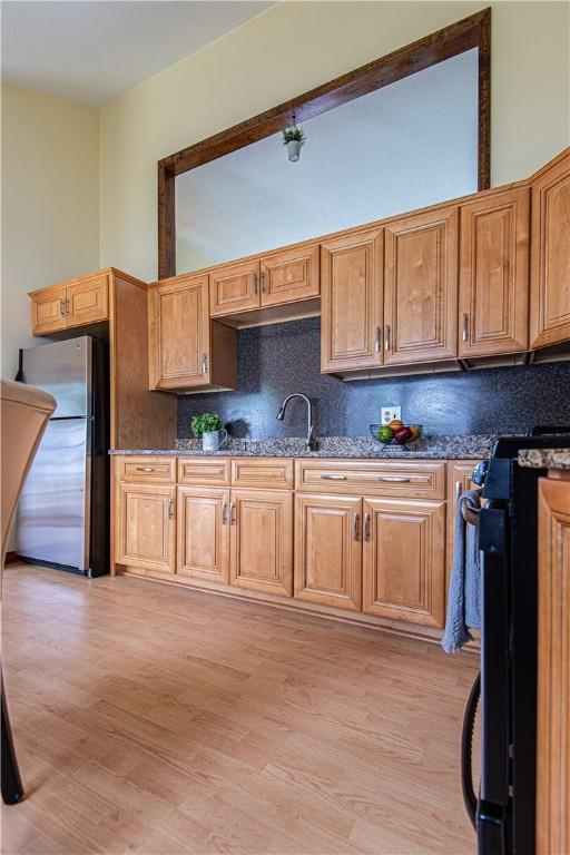 417 Privilege St, Woonsocket, RI 02895 - kitchen with stove, freestanding refrigerator, a sink, and decorative backsplash