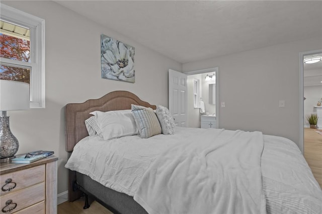 120 Aspinet Dr, Warwick, RI 02888 - bedroom featuring wood finished floors, ensuite bath, and baseboards