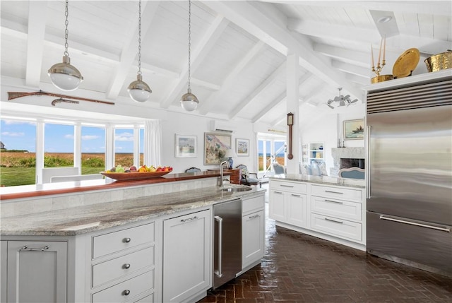 61 Baileys Ledge Rd, Little Compton, RI 02837 - kitchen featuring built in fridge, a sink, light stone countertops, brick floors, and white cabinets