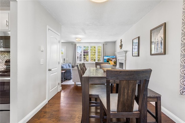 25 Old Pine Rd, Narragansett, RI 02882 - dining room with a textured ceiling, dark wood-style flooring, baseboards, and a fireplace