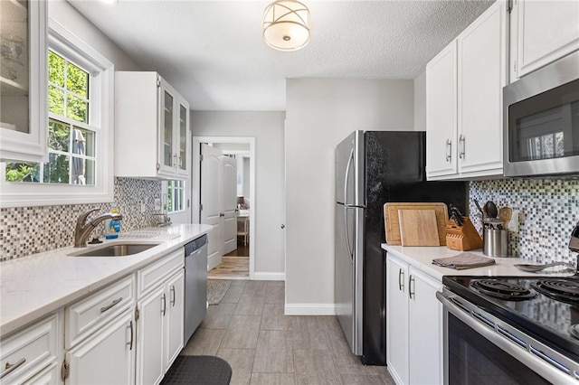 25 Old Pine Rd, Narragansett, RI 02882 - kitchen featuring appliances with stainless steel finishes, a sink, white cabinets, decorative backsplash, and baseboards