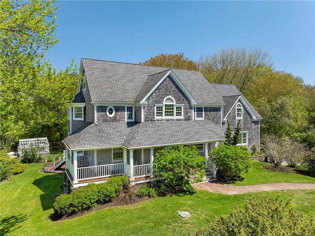 38 Westwind Dr, Jamestown, RI 02835 - shingle-style home with covered porch, a front lawn, and roof with shingles