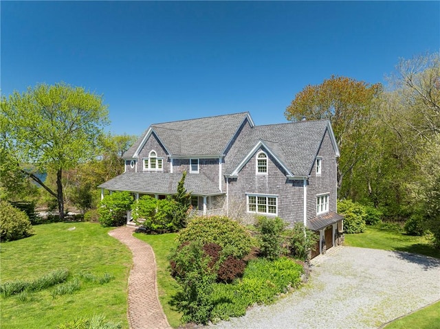 38 Westwind Dr, Jamestown, RI 02835 - shingle-style home with a front lawn, gravel driveway, a garage, and roof with shingles