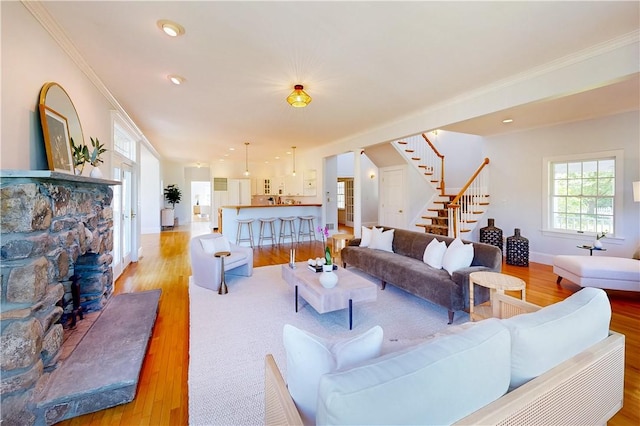 38 Westwind Dr, Jamestown, RI 02835 - living room featuring stairs, light wood finished floors, baseboards, crown molding, and a fireplace