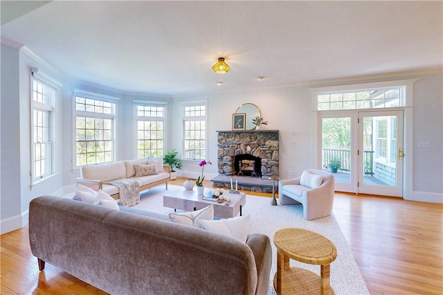 38 Westwind Dr, Jamestown, RI 02835 - living room featuring ornamental molding, baseboards, light wood-style floors, and a stone fireplace