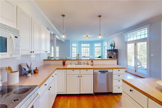 38 Westwind Dr, Jamestown, RI 02835 - kitchen with white appliances, a sink, light wood-type flooring, a peninsula, and ornamental molding