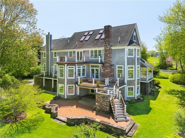 38 Westwind Dr, Jamestown, RI 02835 - rear view of property with a balcony, a chimney, a patio area, stairway, and a lawn