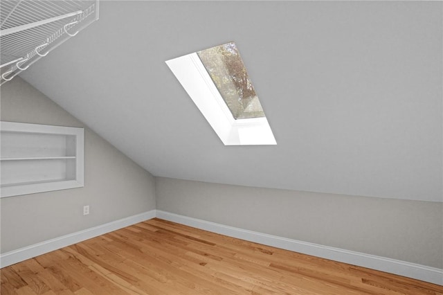888 Plainfield Pike, Coventry, RI 02827 - additional living space featuring a skylight, wood finished floors, baseboards, vaulted ceiling, and built in shelves