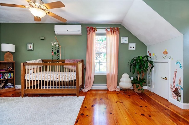 45 Nichols Rd, North Kingstown, RI 02852 - bedroom with a wall mounted air conditioner, wood-type flooring, lofted ceiling, a nursery area, and baseboards