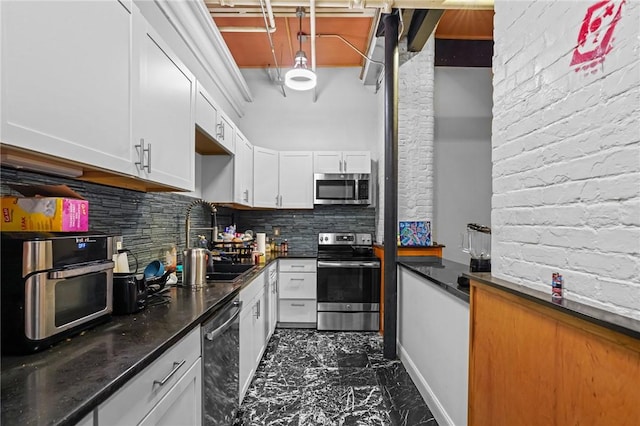 1117 Douglas Ave Unit 120, North Providence, RI 02904 - kitchen with appliances with stainless steel finishes, a sink, dark marble finish flooring, white cabinets, and tasteful backsplash