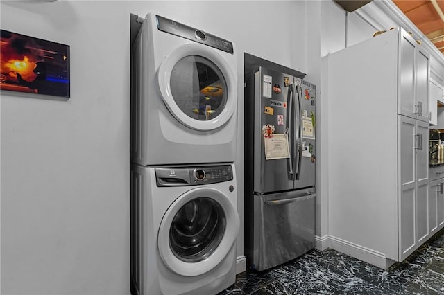 1117 Douglas Ave Unit 120, North Providence, RI 02904 - laundry area with stacked washer / drying machine, dark marble finish flooring, and baseboards