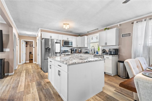 37 Boundary Ave, Providence, RI 02909 - kitchen with stainless steel appliances, ornamental molding, white cabinetry, backsplash, and a textured ceiling