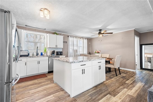 37 Boundary Ave, Providence, RI 02909 - kitchen featuring stainless steel appliances, a sink, a textured ceiling, crown molding, and ceiling fan