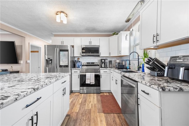 37 Boundary Ave, Providence, RI 02909 - kitchen featuring appliances with stainless steel finishes, a sink, a textured ceiling, light wood-type flooring, and white cabinets