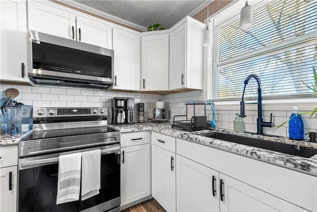 37 Boundary Ave, Providence, RI 02909 - kitchen featuring stainless steel appliances, a sink, white cabinets, a textured ceiling, and tasteful backsplash
