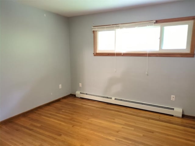 13 Ivy Pl, Lincoln, RI 02865 - empty room with a baseboard heating unit, light wood-type flooring, and baseboards