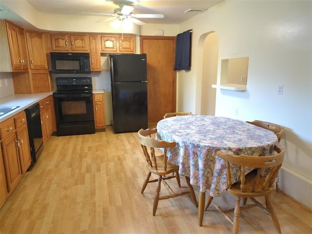 13 Ivy Pl, Lincoln, RI 02865 - kitchen featuring black appliances, arched walkways, light wood-type flooring, a ceiling fan, and brown cabinetry
