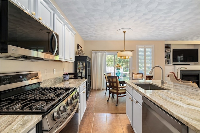 83 Preservation Way S, Kingstown, RI 02879 - kitchen featuring appliances with stainless steel finishes, a sink, light stone counters, white cabinetry, and decorative light fixtures