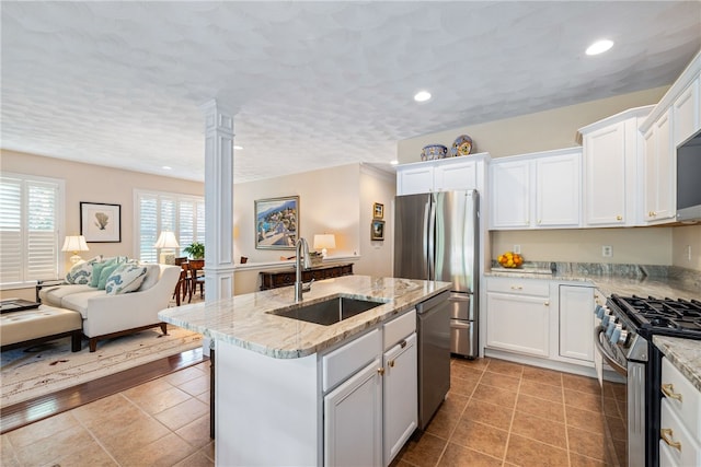83 Preservation Way S, Kingstown, RI 02879 - kitchen featuring stainless steel appliances, a sink, a kitchen island with sink, open floor plan, and decorative columns
