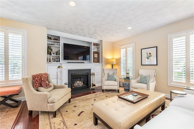 83 Preservation Way S, Kingstown, RI 02879 - living area with a fireplace with flush hearth, recessed lighting, baseboards, wood finished floors, and built in features
