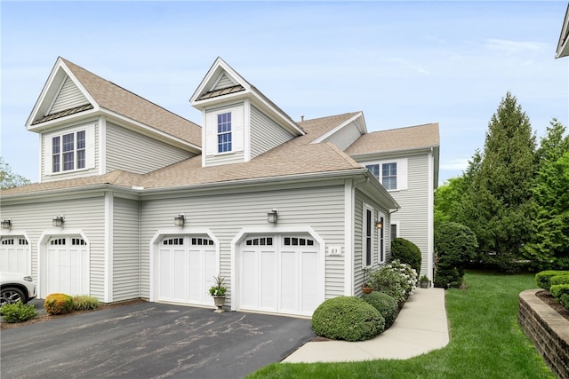 83 Preservation Way S, Kingstown, RI 02879 - view of side of home featuring driveway, a lawn, roof with shingles, and a garage