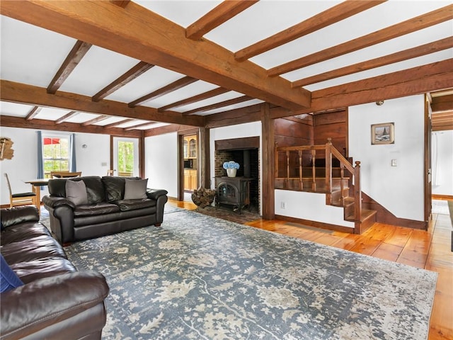 12 Rustic Acres Dr, Glocester, RI 02814 - living room featuring stairs, hardwood / wood-style flooring, beamed ceiling, and a wood stove