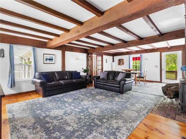 12 Rustic Acres Dr, Glocester, RI 02814 - living room with beamed ceiling, wood-type flooring, baseboards, a wood stove, and healthy amount of natural light