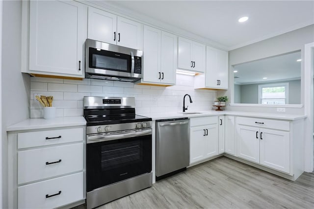 31 Forbes St, East Providence, RI 02915 - kitchen featuring appliances with stainless steel finishes, a sink, light countertops, white cabinetry, and light wood finished floors