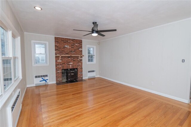 70 Enfield Ave, Providence, RI 02908 - unfurnished living room featuring radiator, a ceiling fan, light wood-type flooring, a wall mounted air conditioner, and crown molding